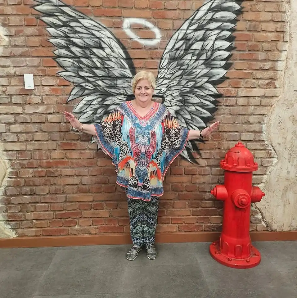 AngelSpeak NZ practitioner at a wing mural